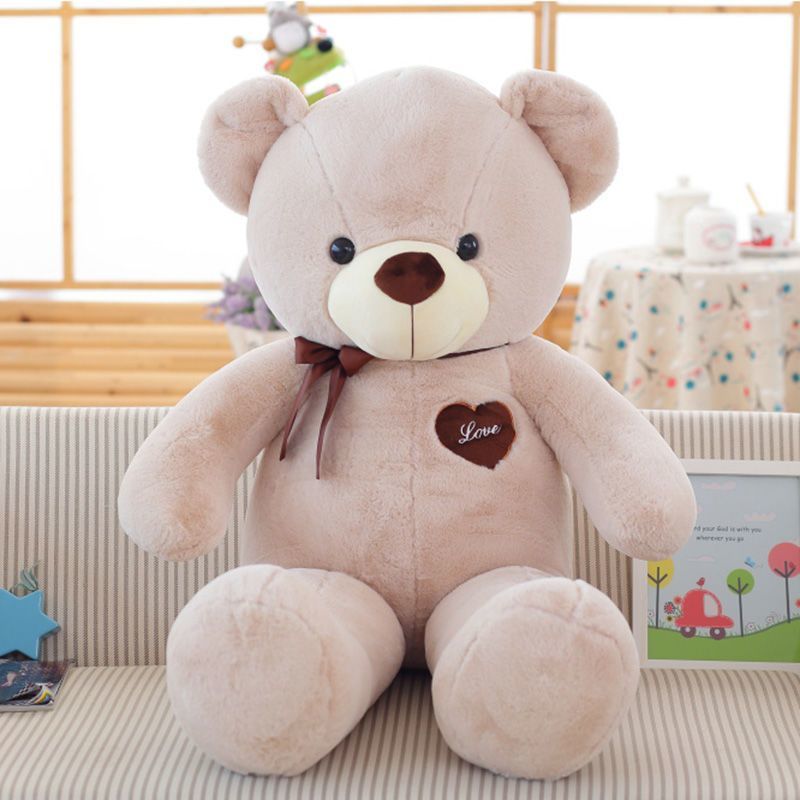 Khaki Love Bear giant khaki teddy bear sitting on a striped sofa