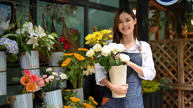 A florist arranging a fresh flower bouquet in a flower shop